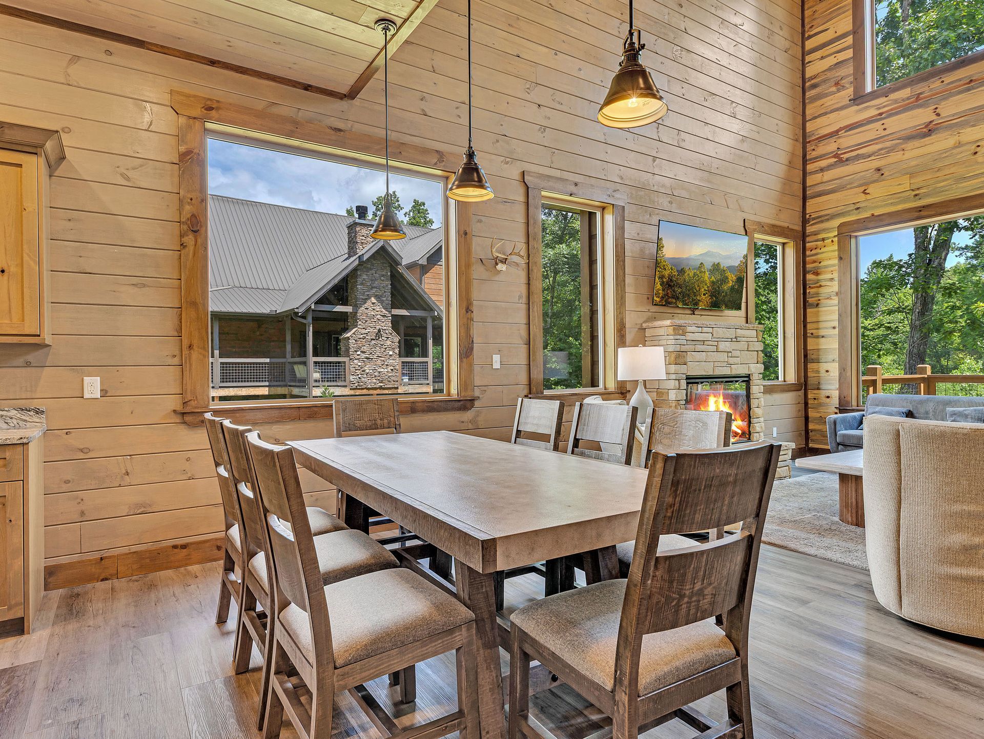 Dining room with wooden table, chairs, and a view of the exterior.