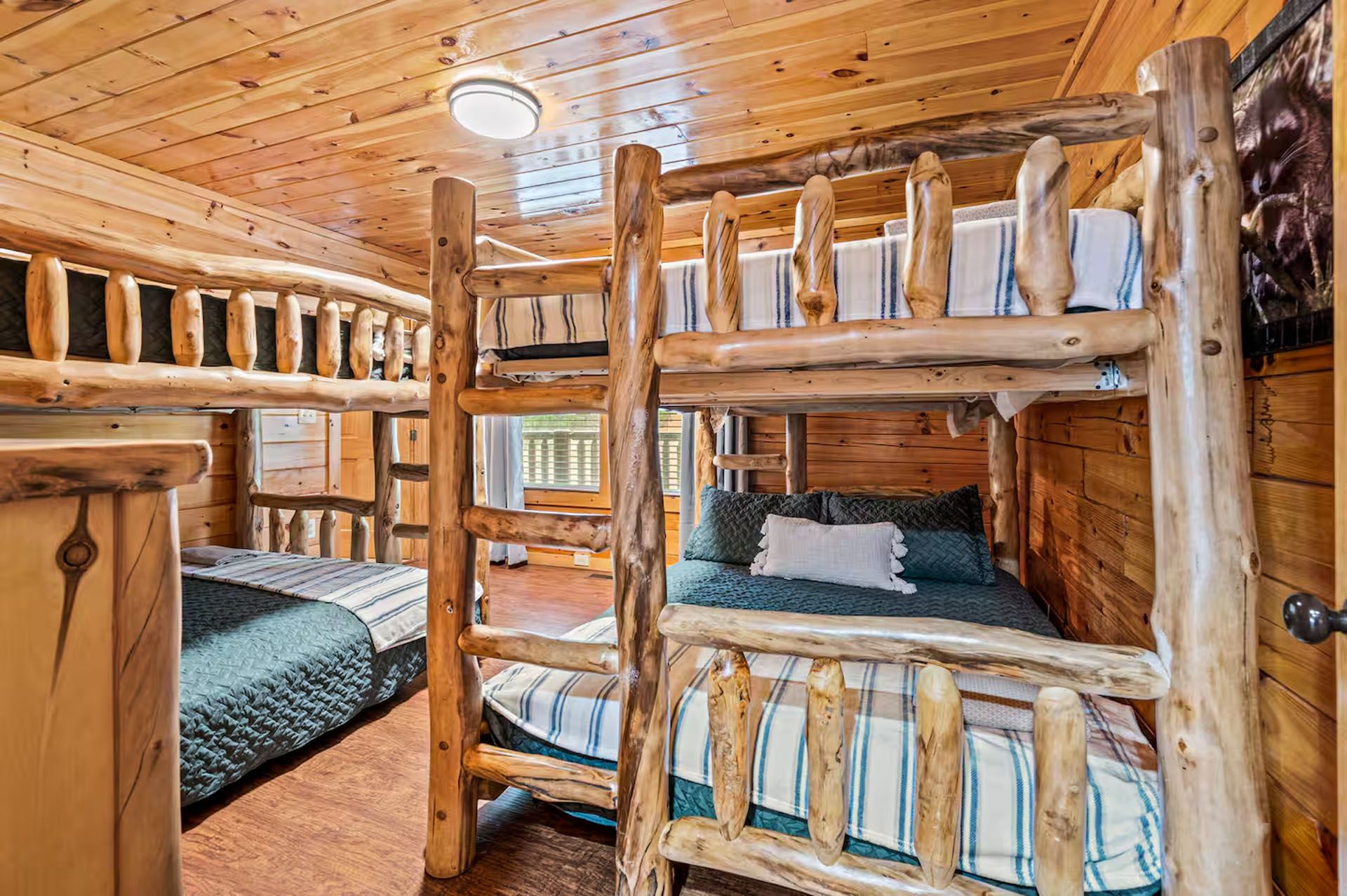 Rustic wood bunk beds in a cabin bedroom with a wood ceiling and walls.