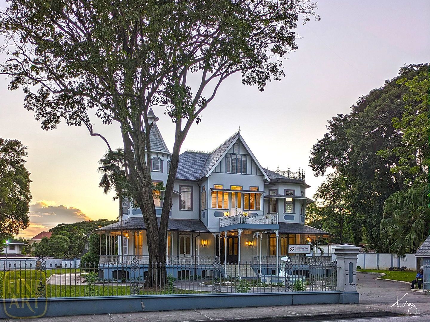 A large house with a lot of windows is surrounded by trees.