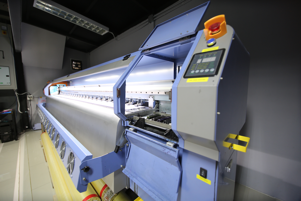 A large printing machine is sitting in a room.