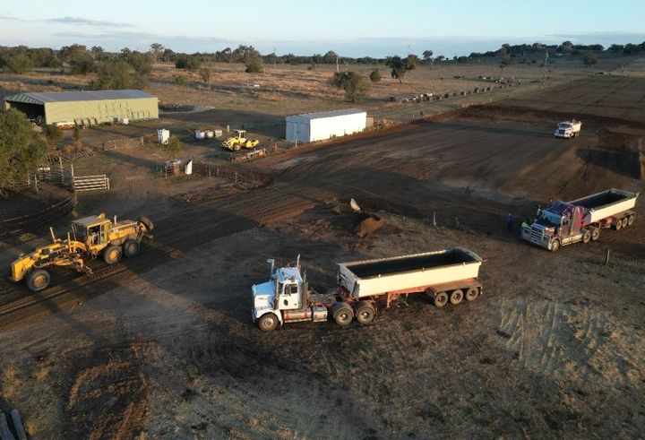 An aerial view of a construction site with trucks and tractors.