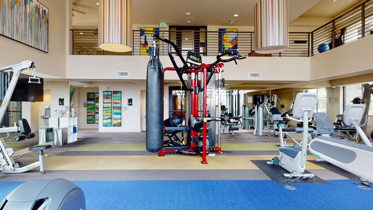 A large gym with a lot of equipment and a blue floor.