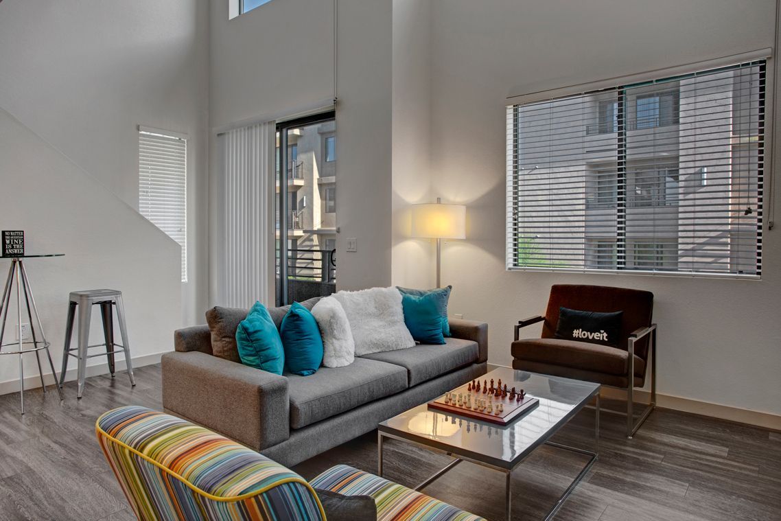 A living room with a couch , chairs , coffee table and a chess board.