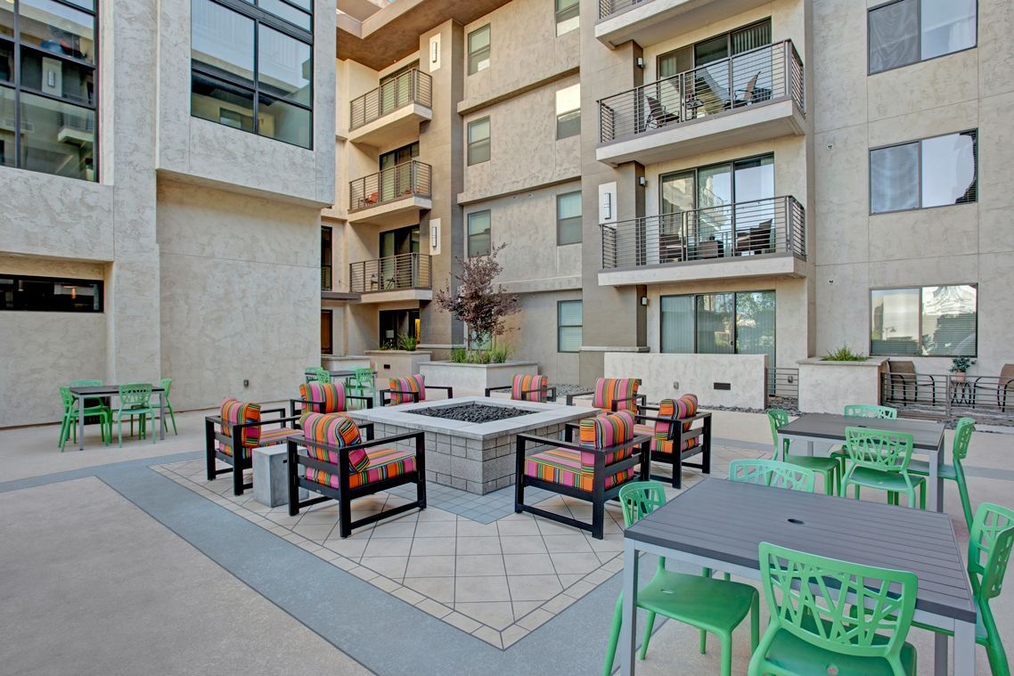 There is a fire pit in the middle of the courtyard of a building.