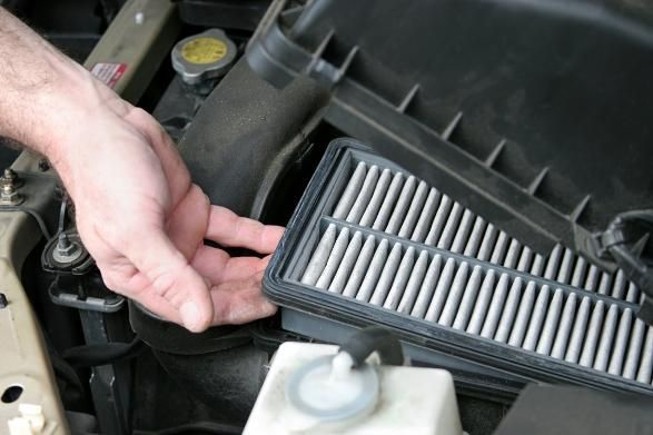 A Person Is Holding a Filter in Their Hand Under the Hood of A Car — SVS Autocare in Kunda Park, QLD