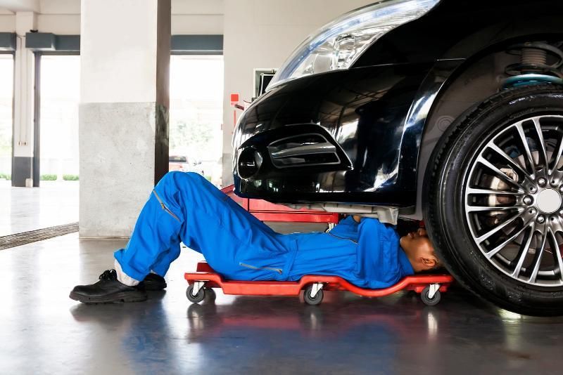 A Mechanic Is Laying Under a Car in A Garage — SVS Autocare in Kunda Park, QLD