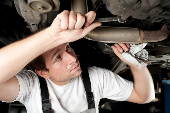 A Man Is Working Under a Car with A Wrench — SVS Autocare in Kunda Park, QLD