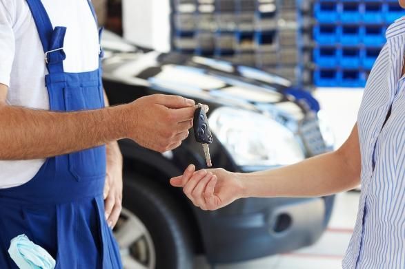 A Man Is Handing a Woman a Car Key in A Garage — SVS Autocare in Kunda Park, QLD