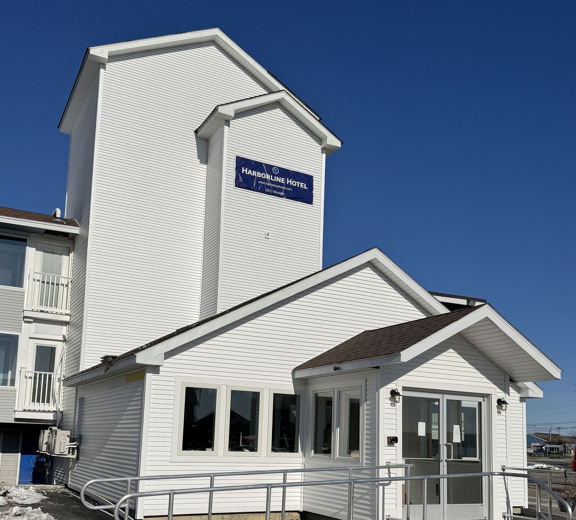 A white building with a blue sign on the side that says ' motel '