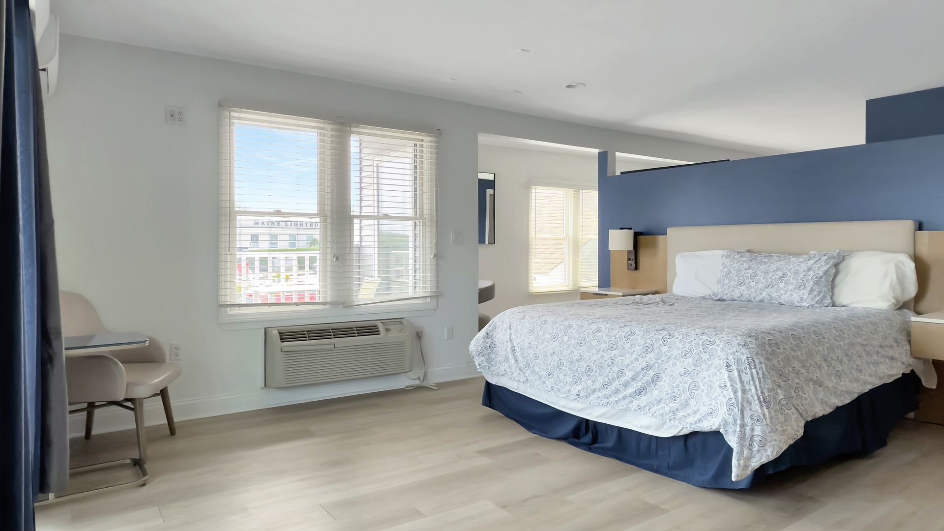 Hotel bedroom with a bed, window, and seating area.