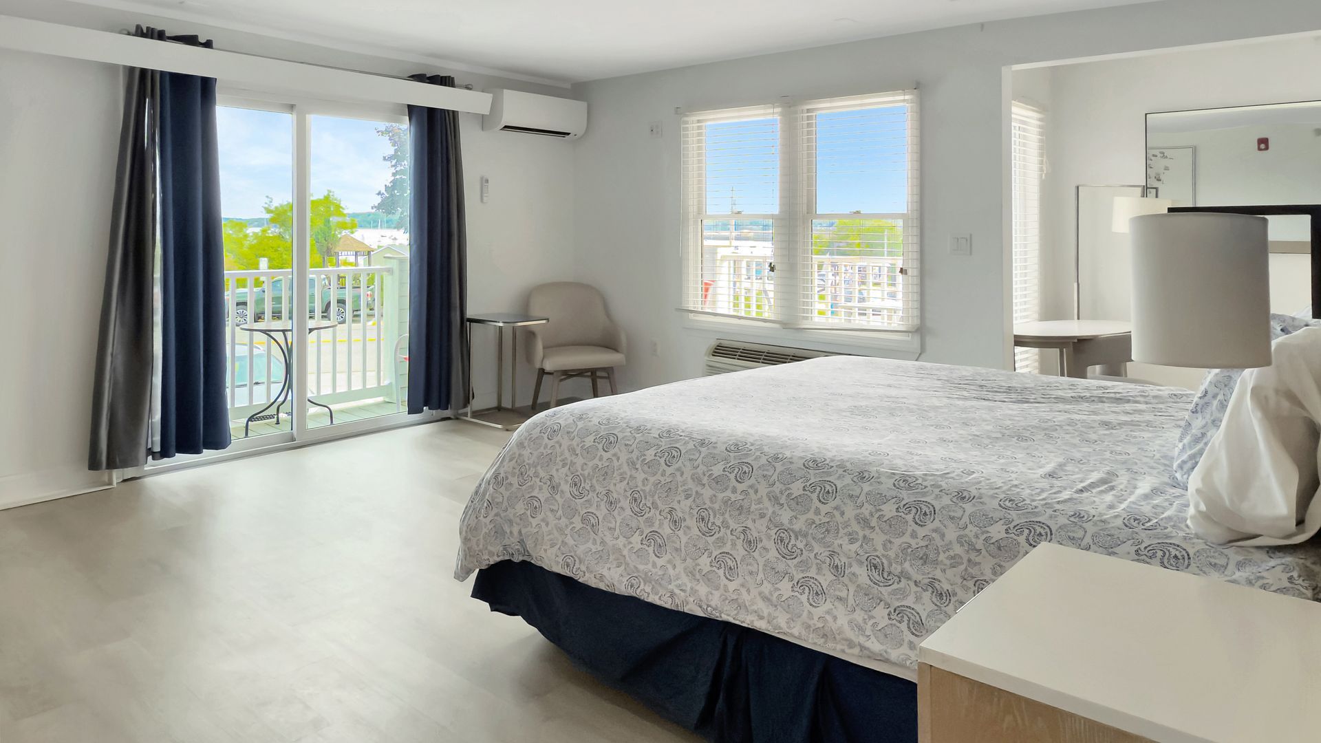 Bedroom with bed, balcony access, and city views.
