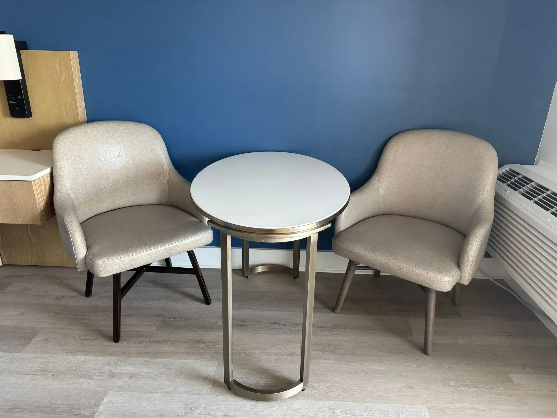 A hotel room with two chairs and a table