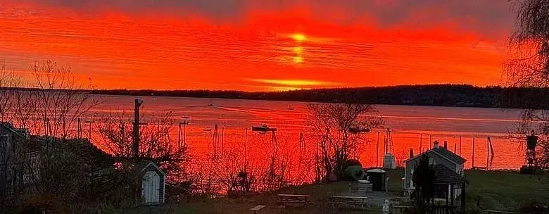 A sunset over a body of water with a red sky