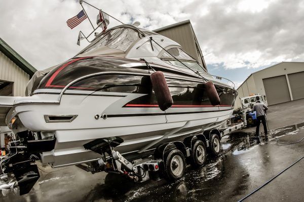 A boat is sitting on a trailer in front of a building.