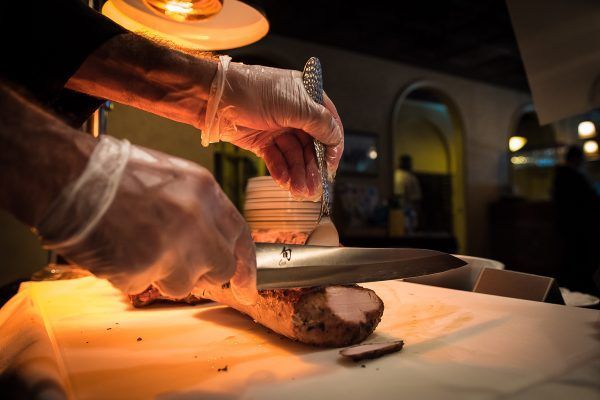 A person is cutting a piece of meat on a cutting board.