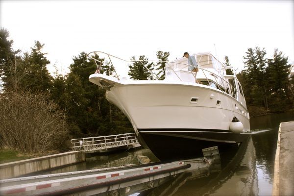 A large white boat is being loaded into the water.