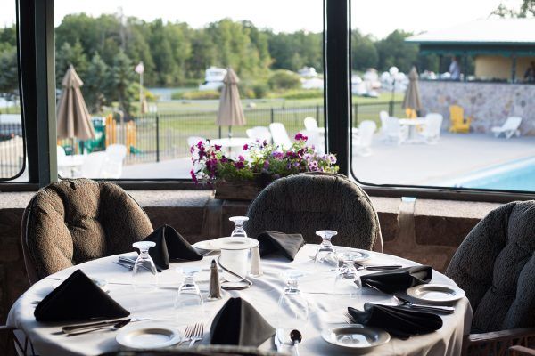 A restaurant with a table and chairs and a view of a pool.
