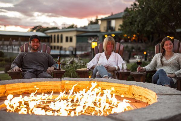 A group of people are sitting around a fire pit.