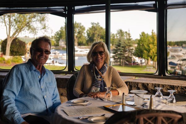 A man and a woman are sitting at a table in front of a window.