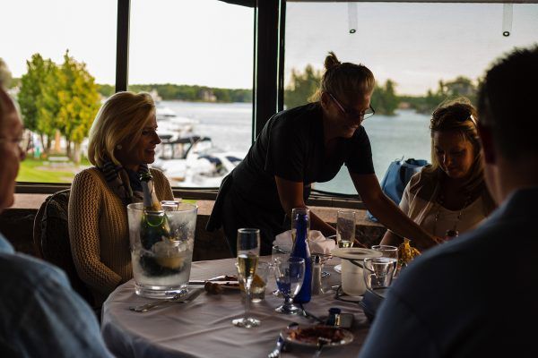 A waitress is serving a group of people at a table