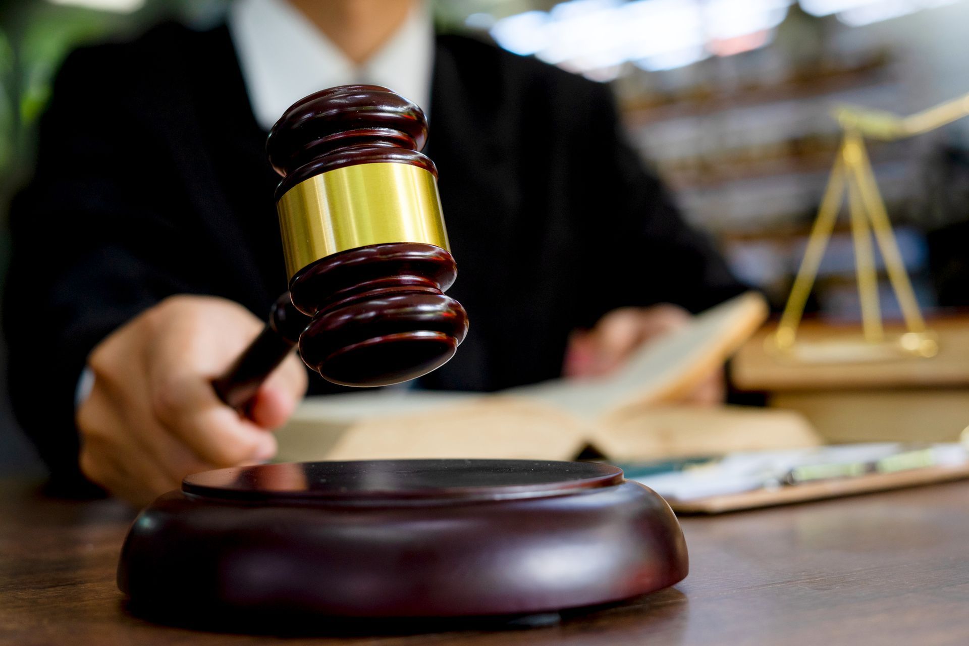 A judge is holding a wooden gavel in his hand.