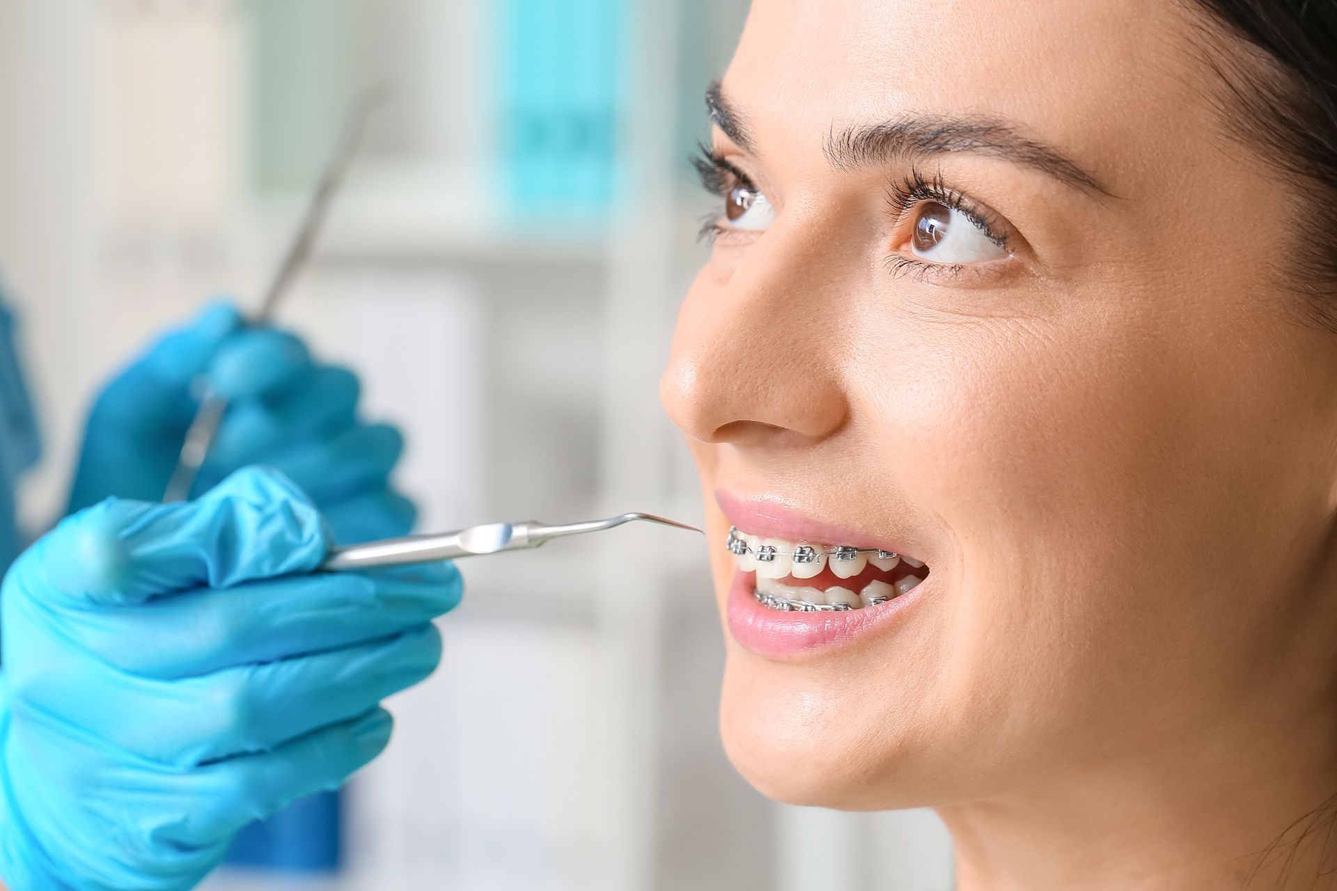 Primo piano di una persona sorridente con le mani che sfiorano delicatamente i lati del viso.