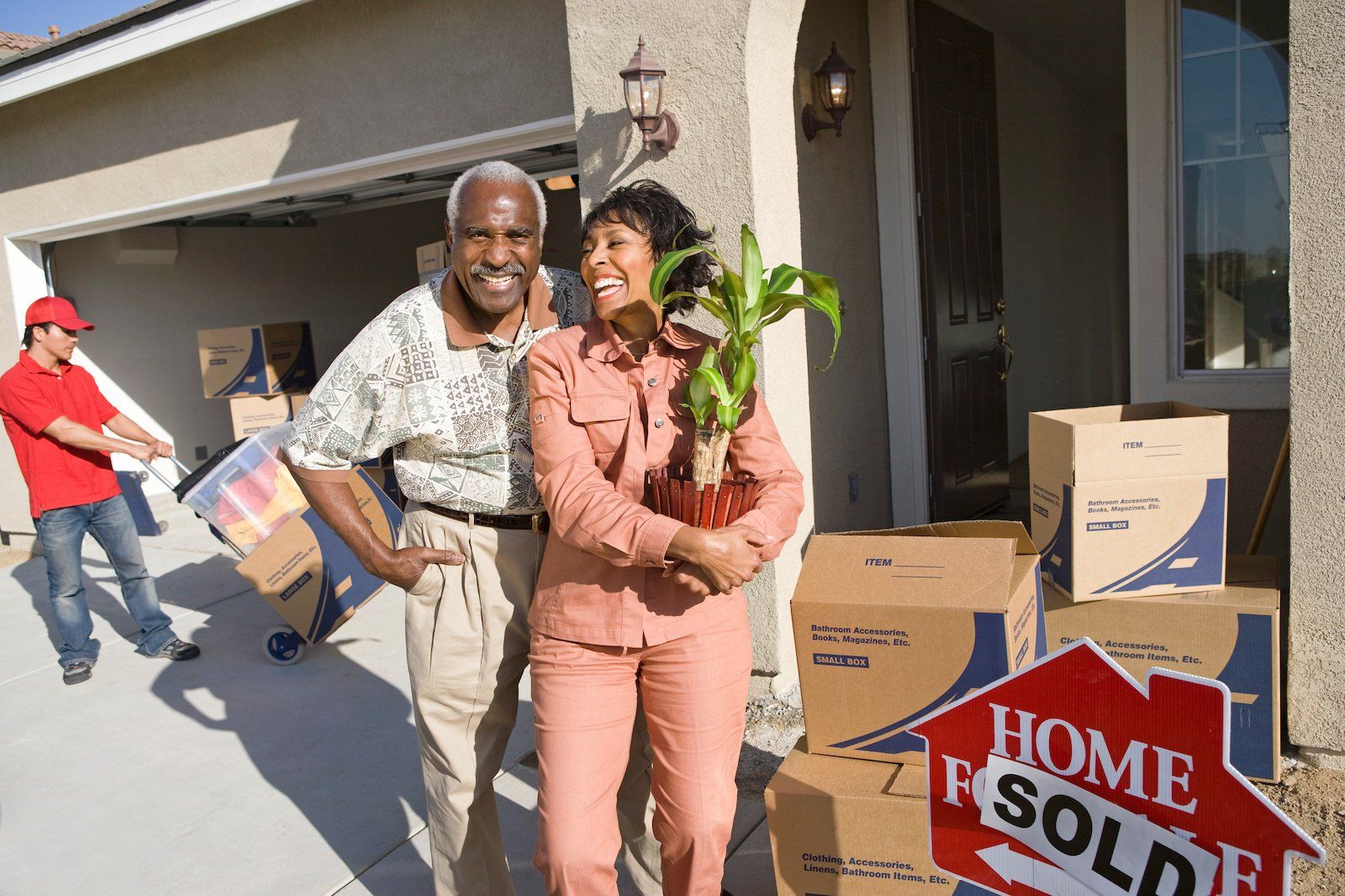 Joyful African American couple excitedly moving their belongings into their new home.