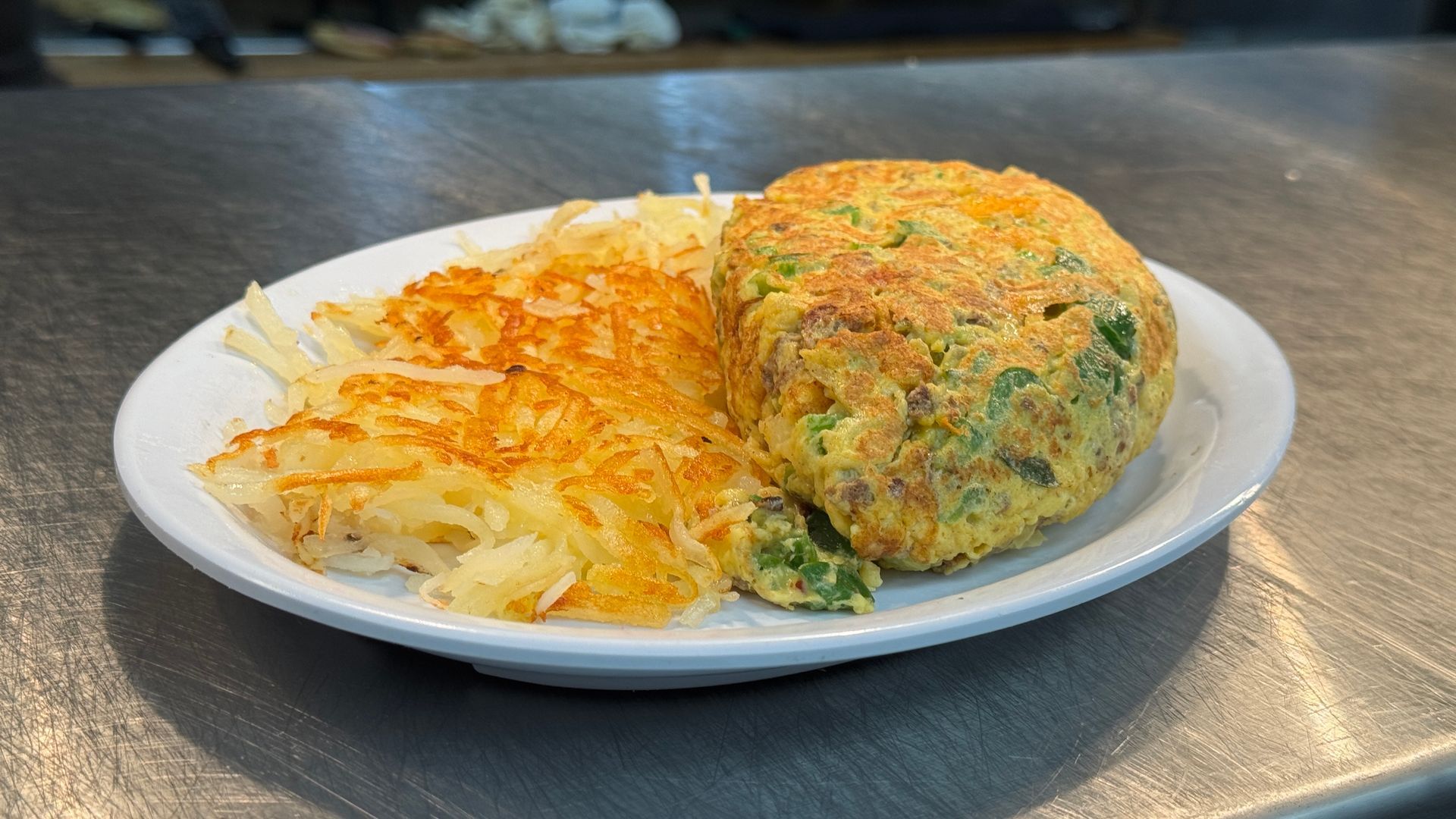 A plate of food with eggs and hash browns on a table.