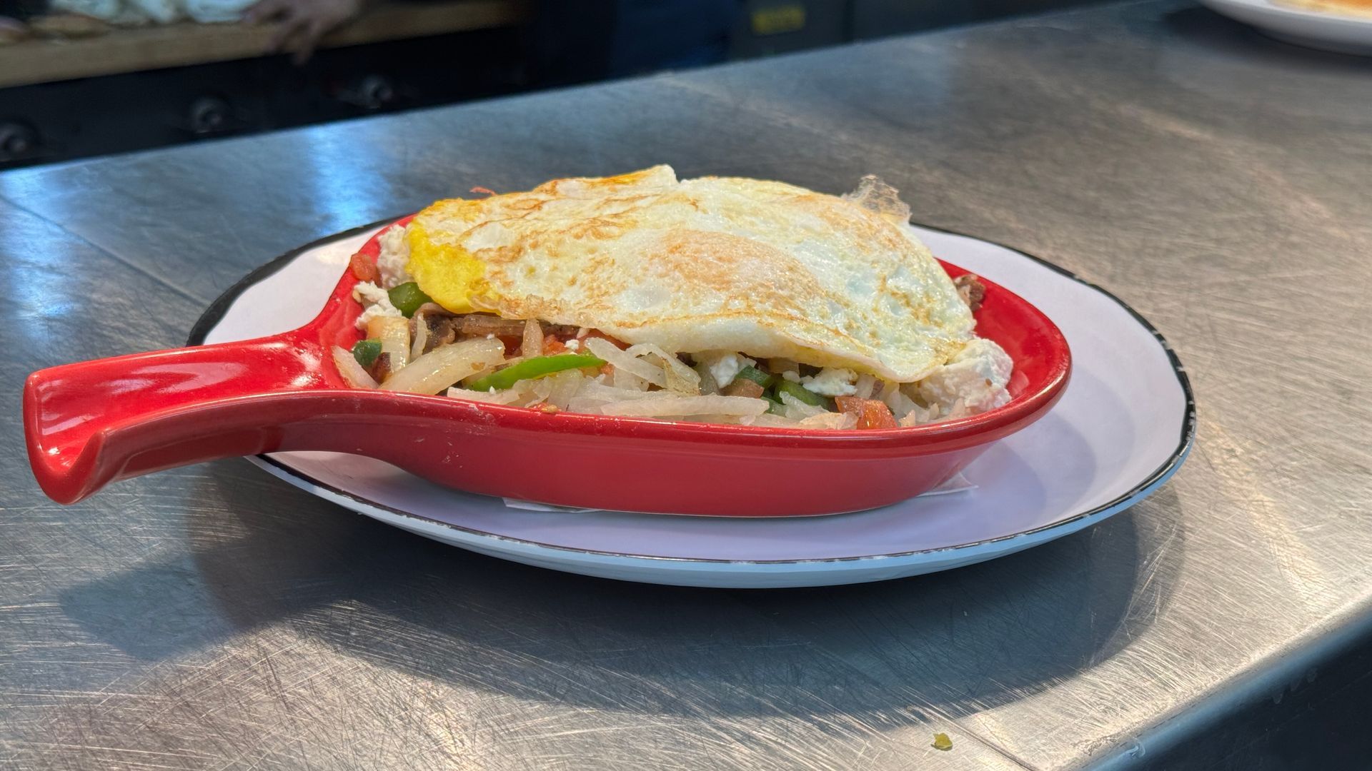 A plate of food with eggs and hash browns on a table.