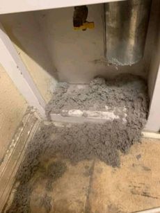 There is a lot of dust in the corner of a room.