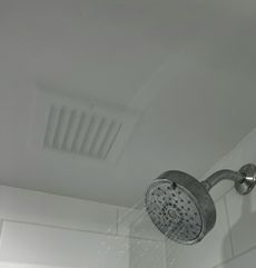 A shower head is spraying water from the ceiling