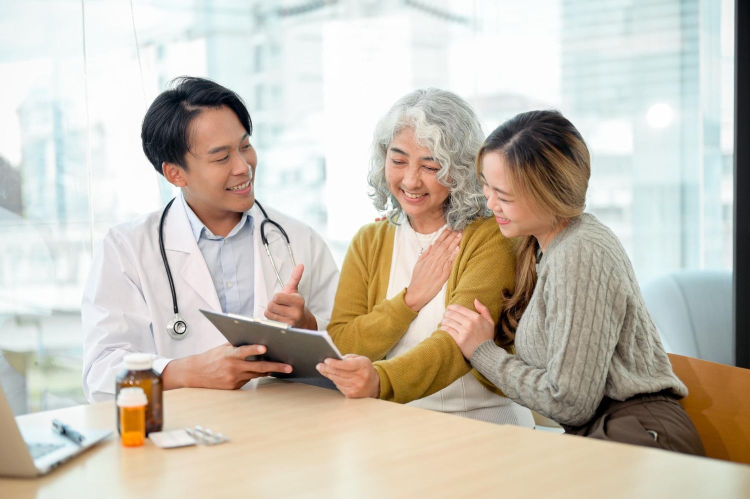 Doctor reviewing a tablet with two smiling patients in a bright clinic