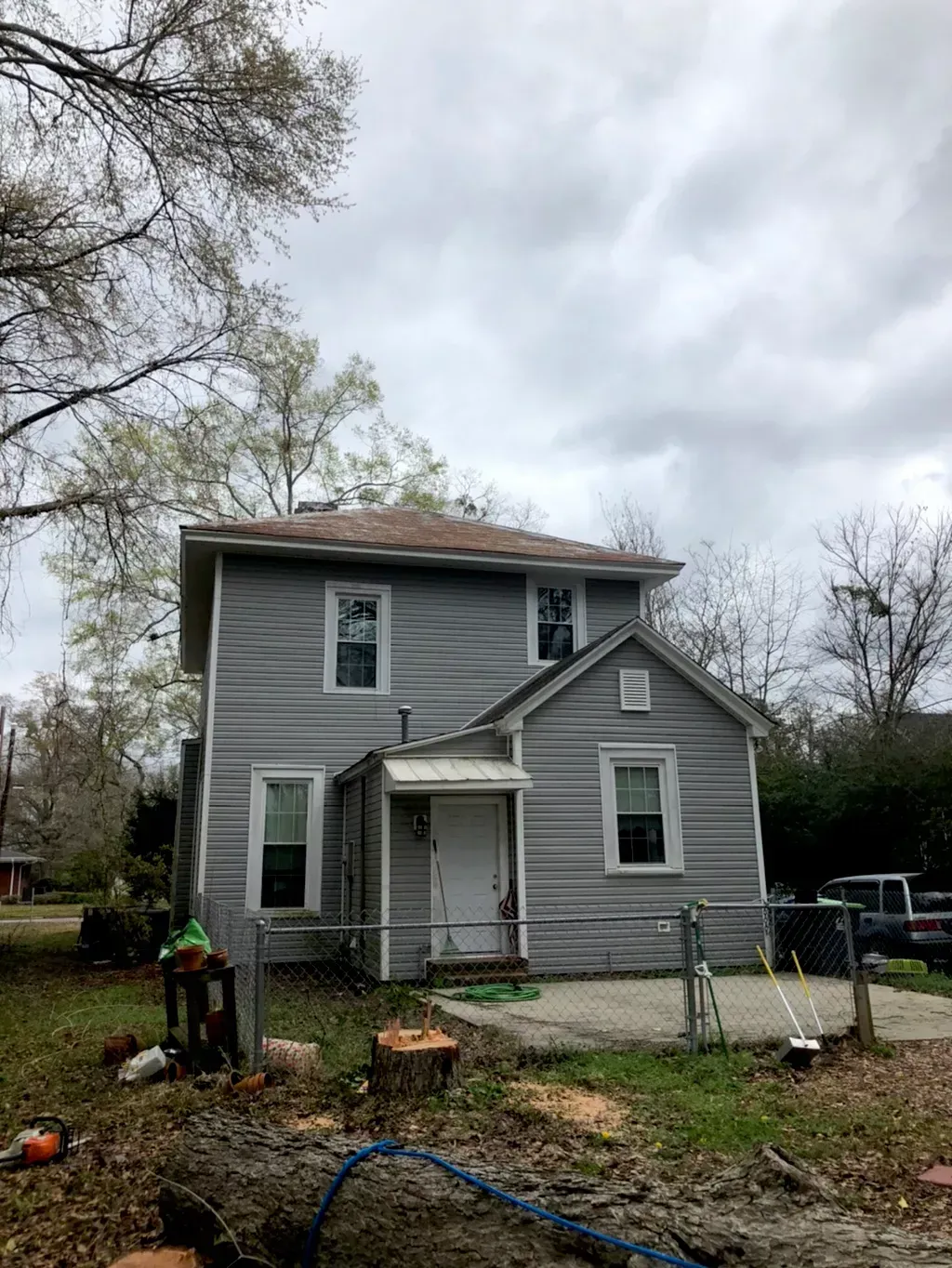 A house with a lot of windows and a fence in front of it.