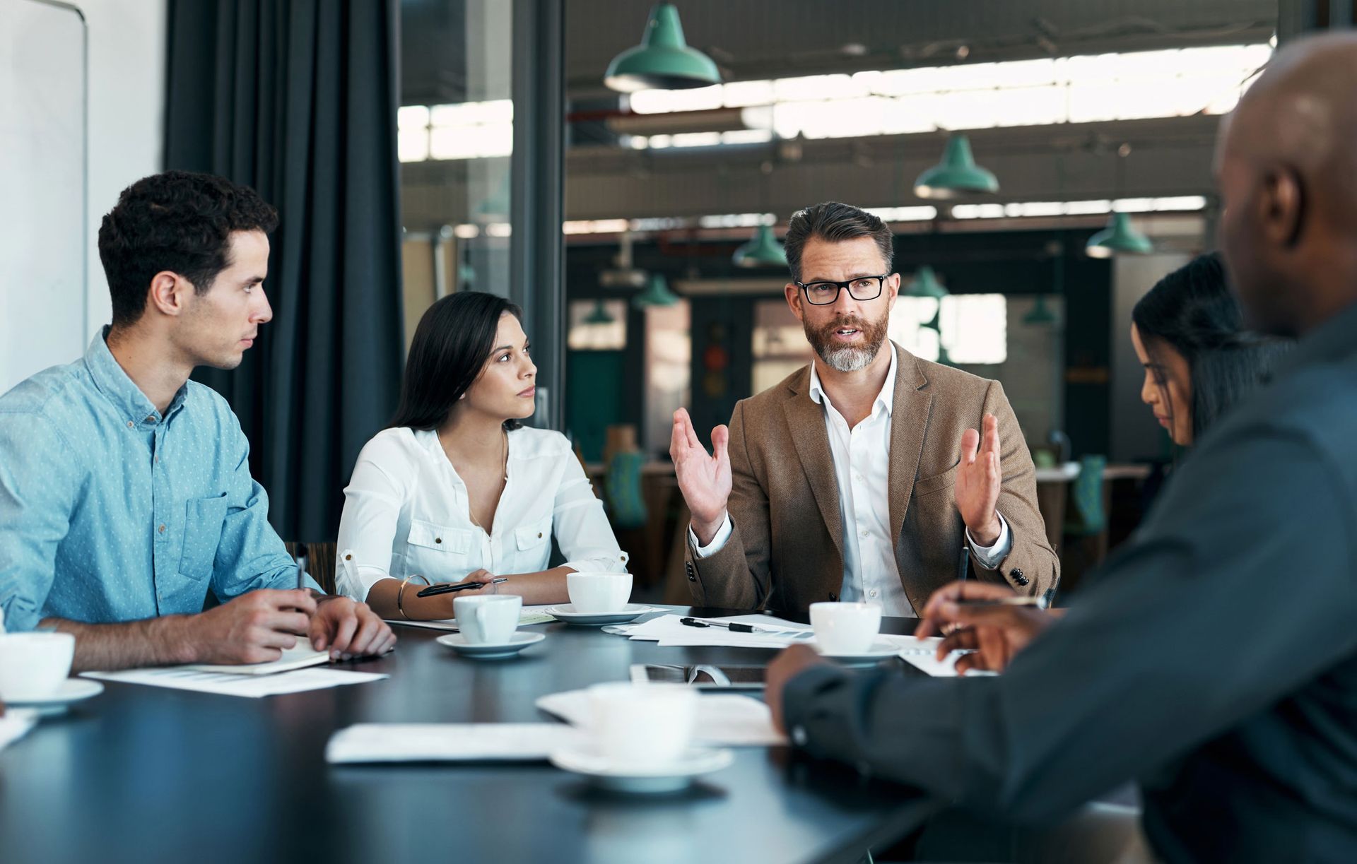 A group of people are sitting around a table having a meeting.