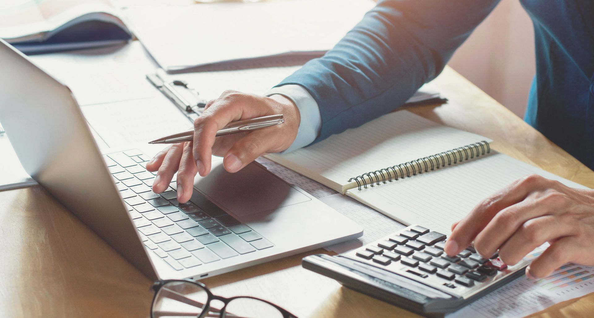 A person is using a laptop and a calculator at the same time.
