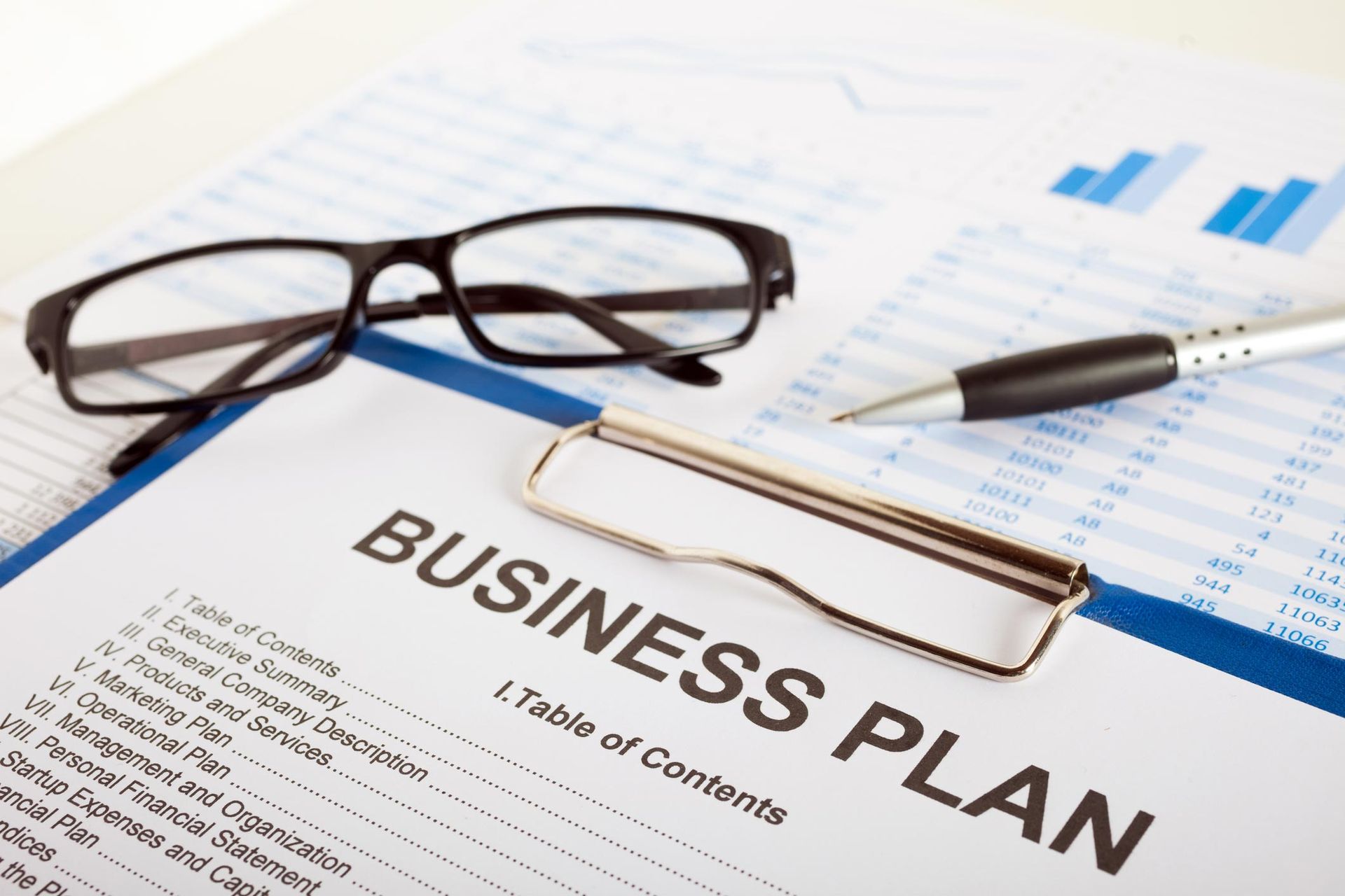 A business plan with a pen and glasses on it