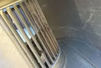 a close up of a dirty air vent on a wall .