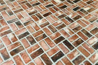 a close up of a brick floor with a herringbone pattern .