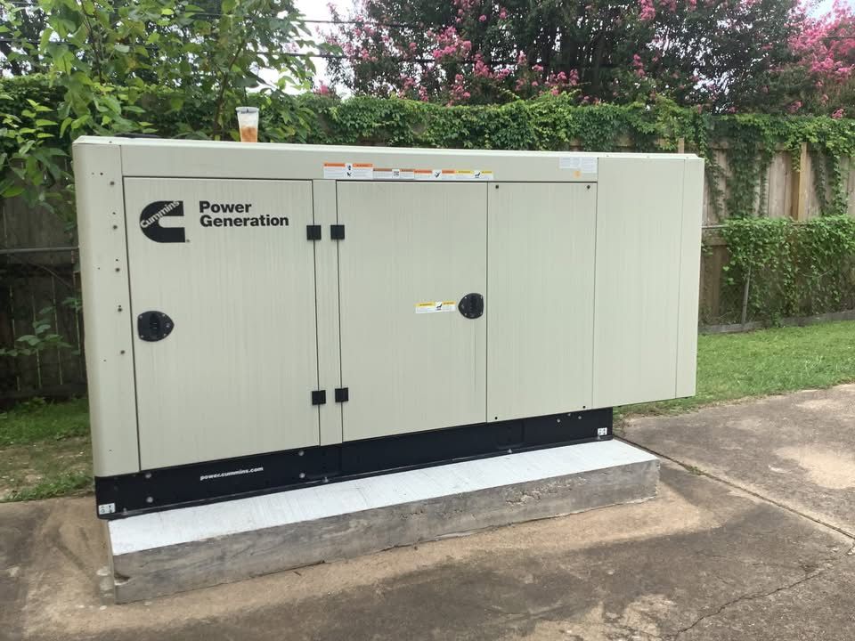 Tan Cummins Power Generation generator on a concrete pad outdoors with a green backdrop.