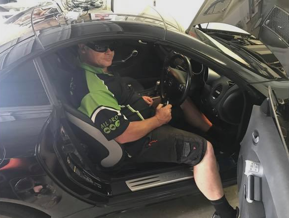 Man Wearing Sunglasses Sits in a Black Sports Car — All Pro Locksmiths In Port Macquarie, NSW