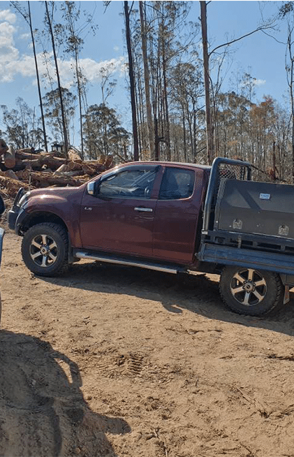 Red Pickup Truck With a Flatbed in a Dirt Clearing — All Pro Locksmiths In Port Macquarie, NSW