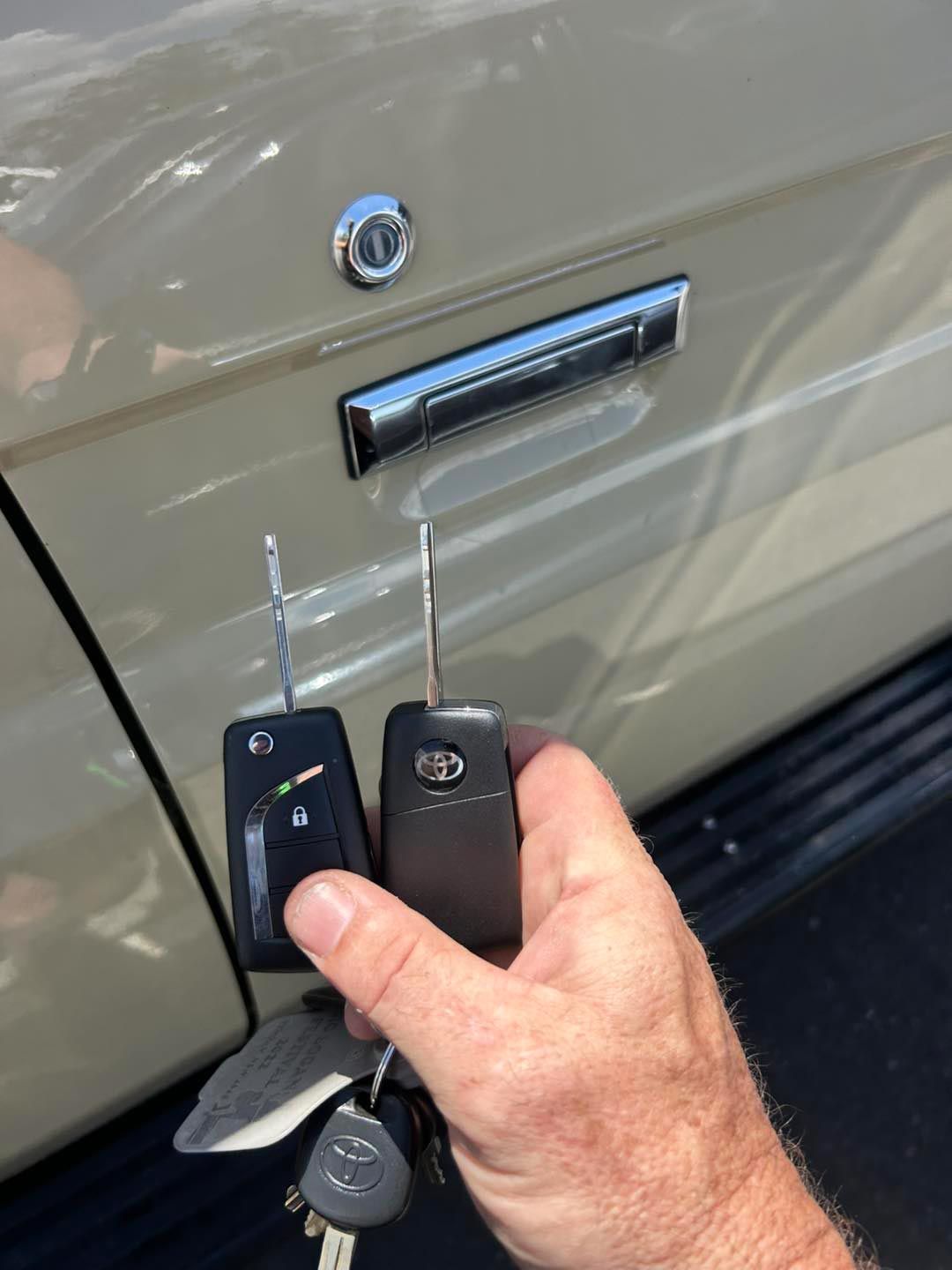 Hand Holding Car Keys Near a Beige Car Door — All Pro Locksmiths In Port Macquarie, NSW