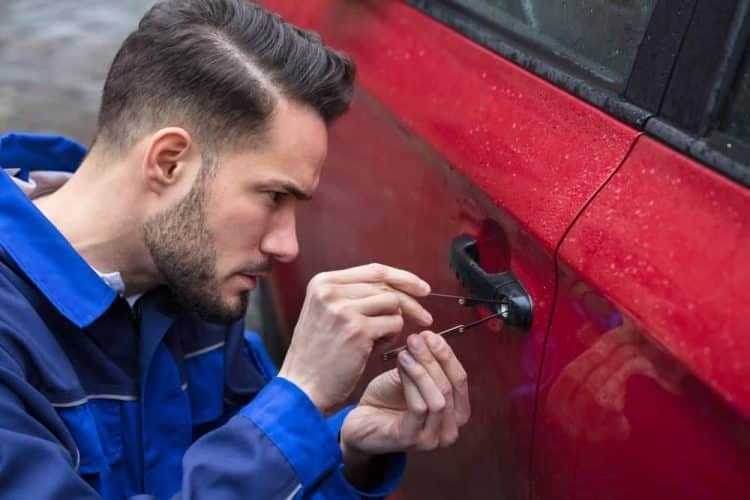Man Picking a Car Lock With Lockpicks on a Red Car, Outdoors — All Pro Locksmiths In Port Macquarie, NSW
