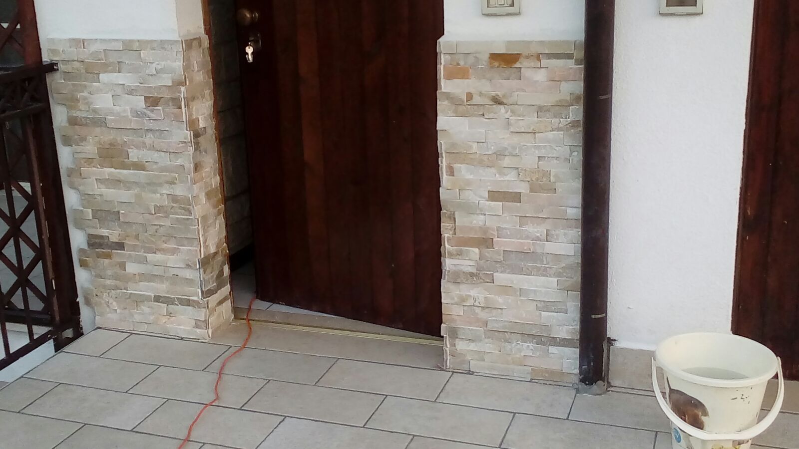 Un secchio bianco è appoggiato a terra davanti a un edificio.