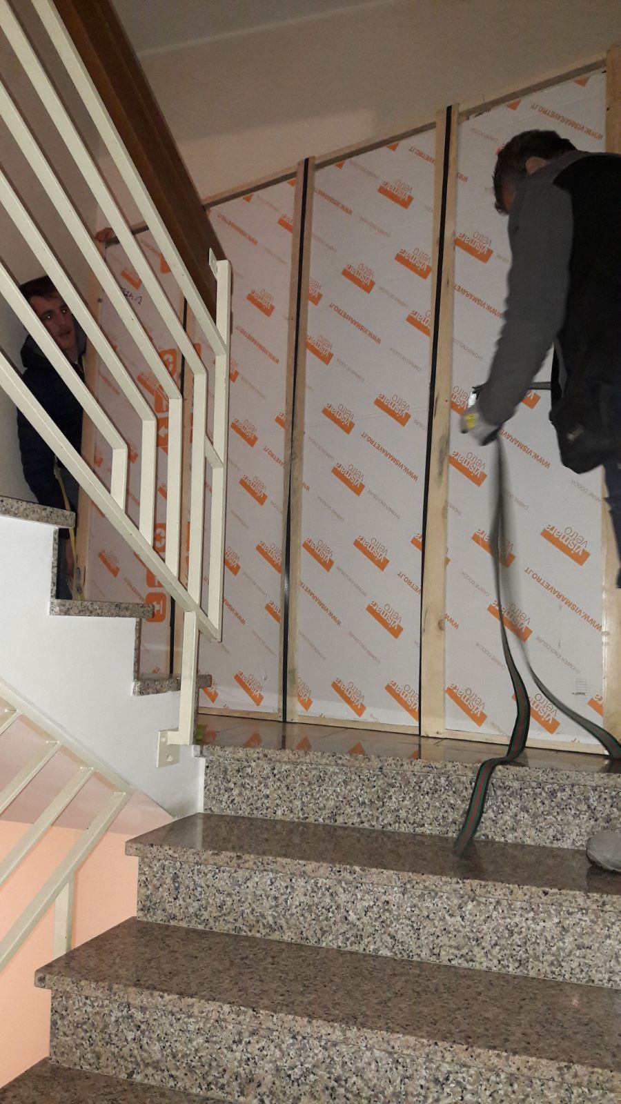 Un uomo è in piedi su una rampa di scale e tiene in mano un tubo