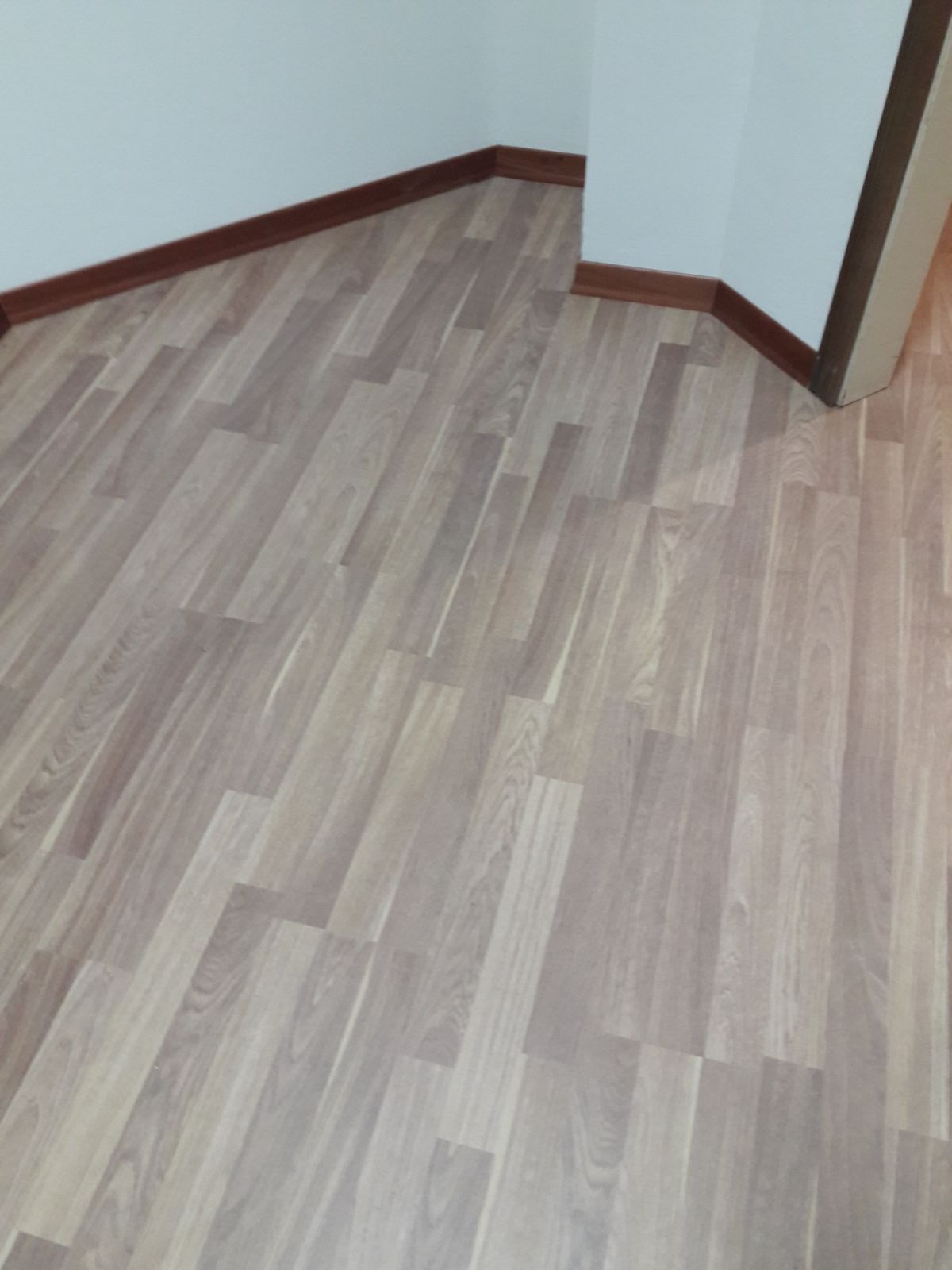 Un angolo di una stanza con pavimento in legno