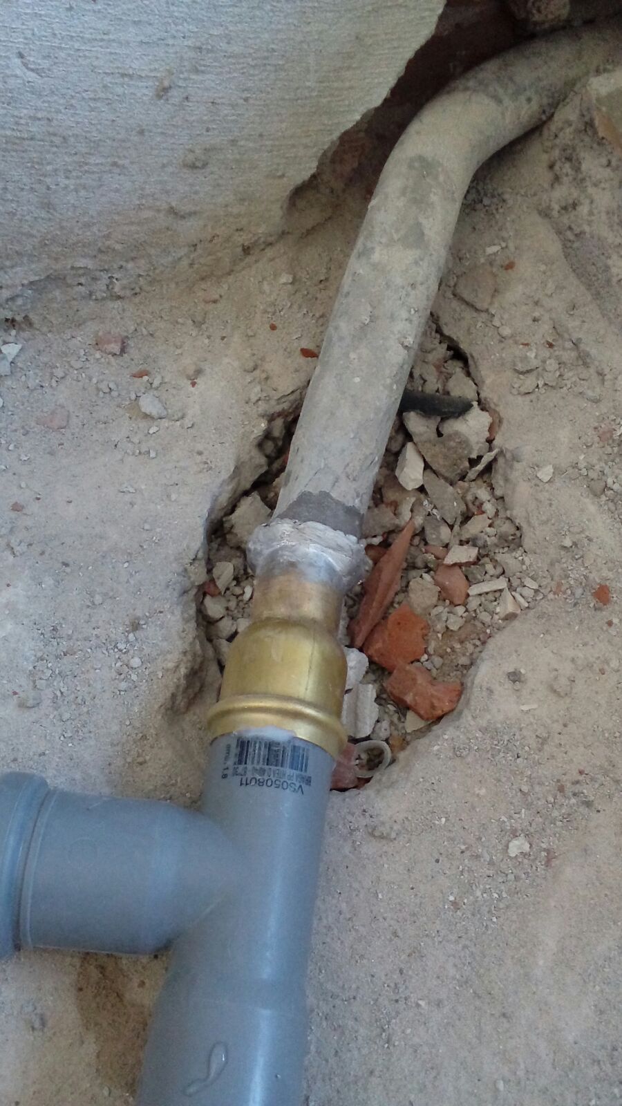 Primo piano di un tubo flessibile collegato a un tubo a terra.