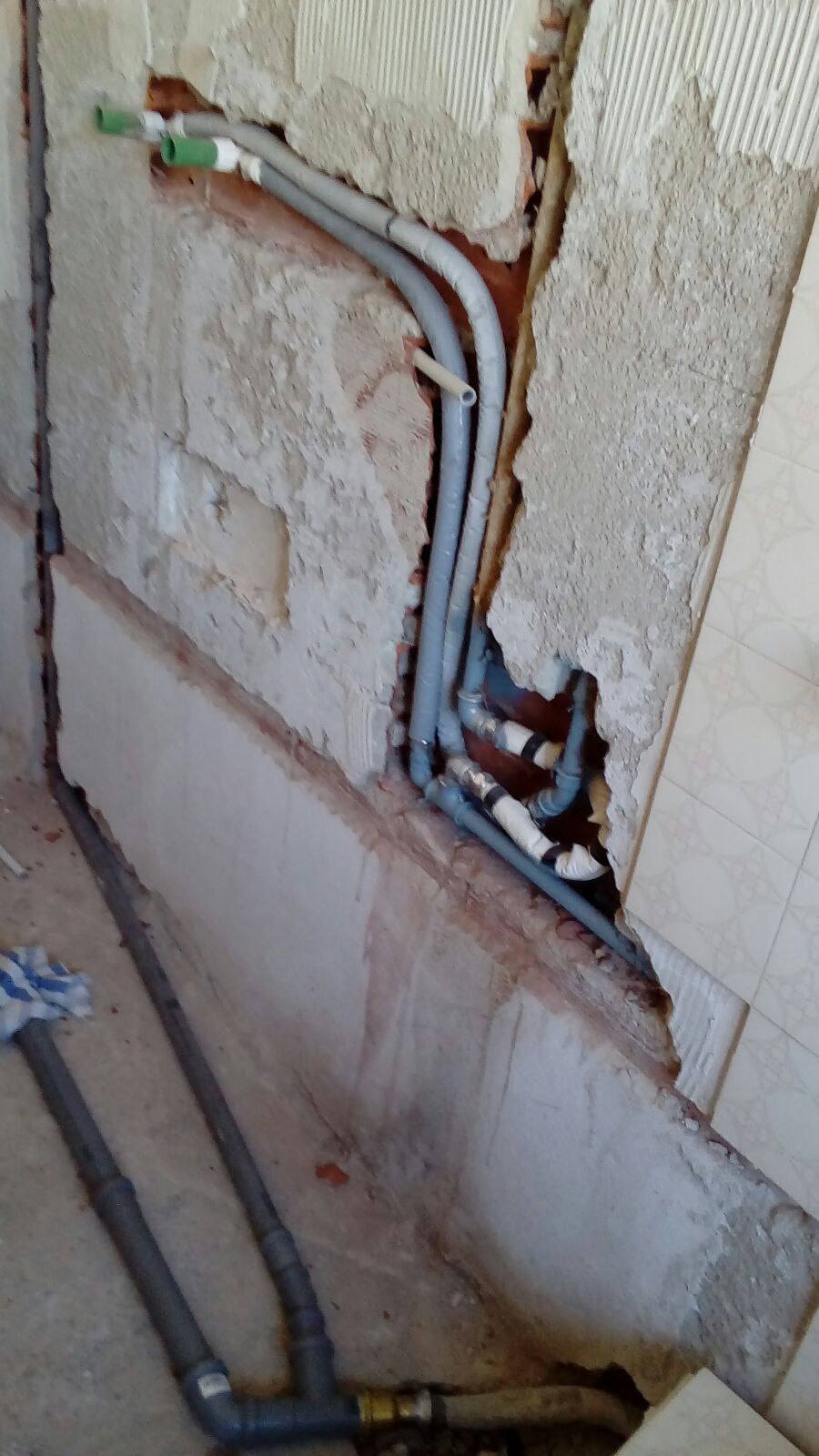 Un muro rotto da cui escono un mucchio di tubi.