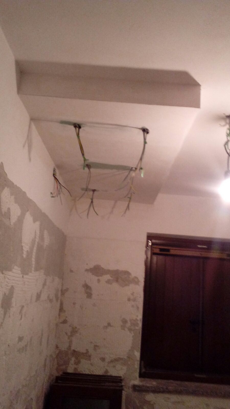 Una stanza con il soffitto in fase di ristrutturazione e una finestra.