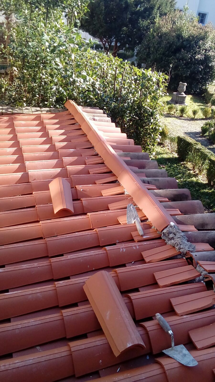 Un tetto con tegole rosse e una cazzuola sopra.